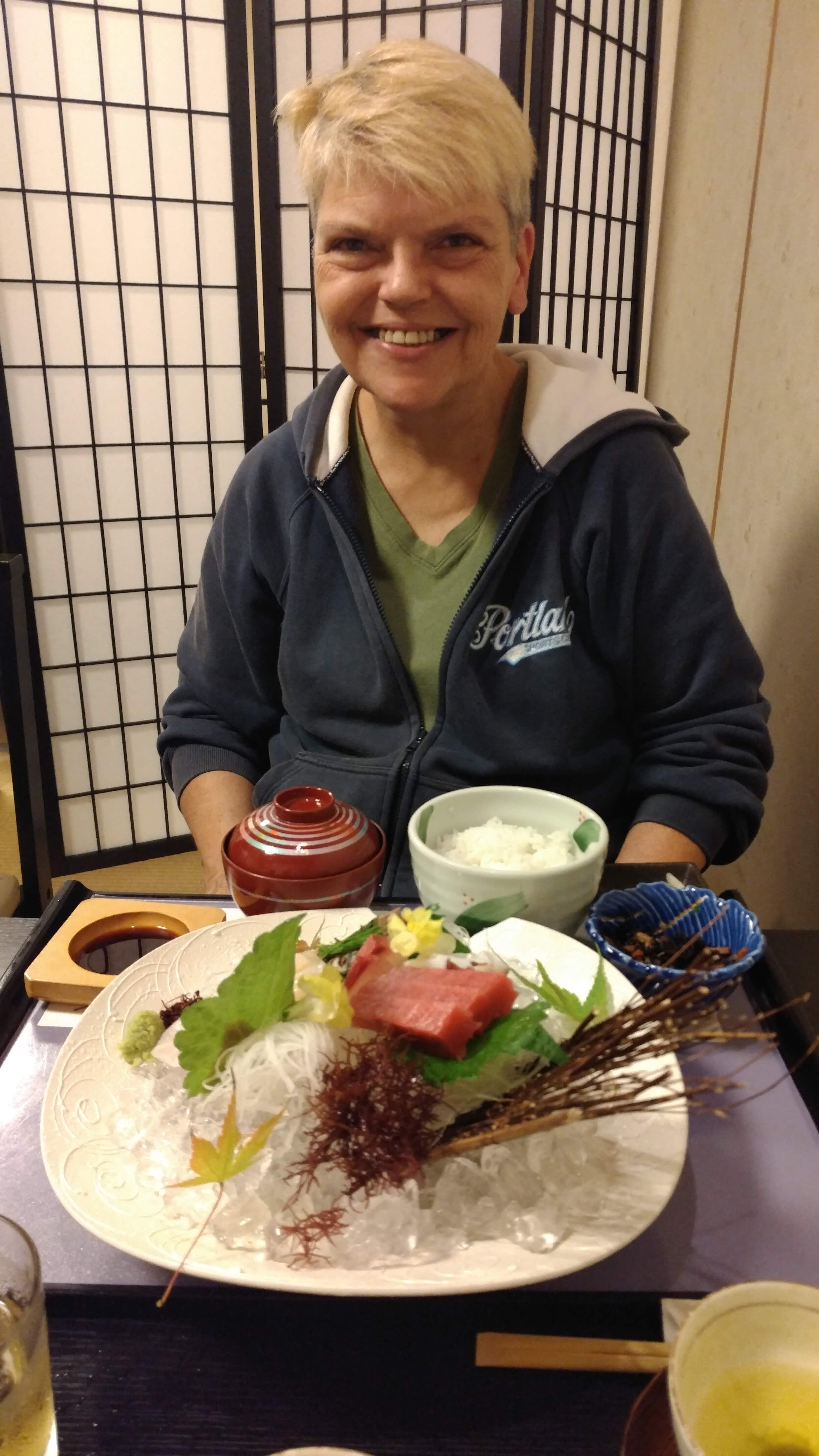 Brenda smailes with her plate of tuna, noodles, and side dishes