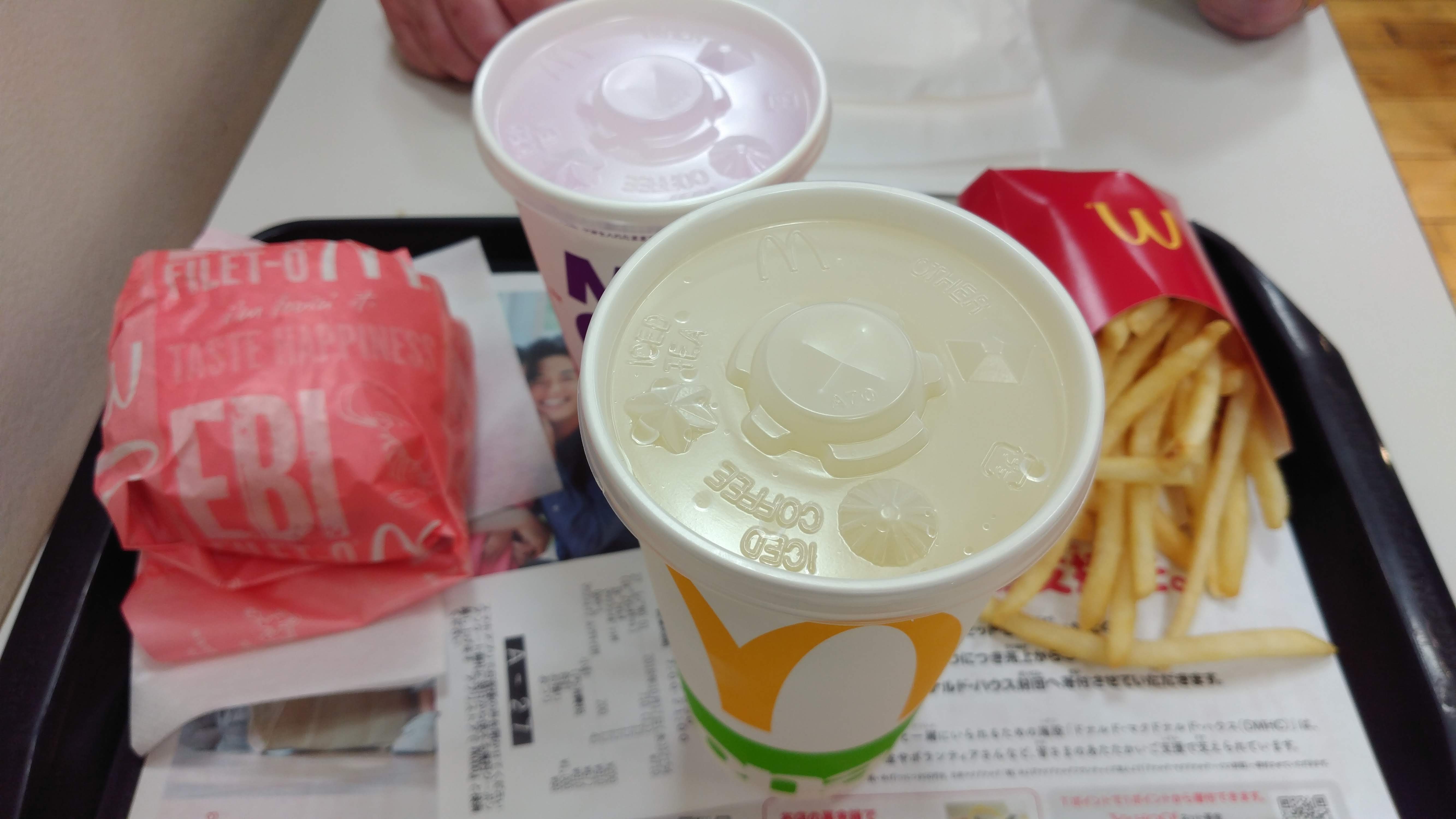 a tray of McDonald's food items  the word Ebi is visible on a sandwich wrapper and there are two drinks and an order of french fries