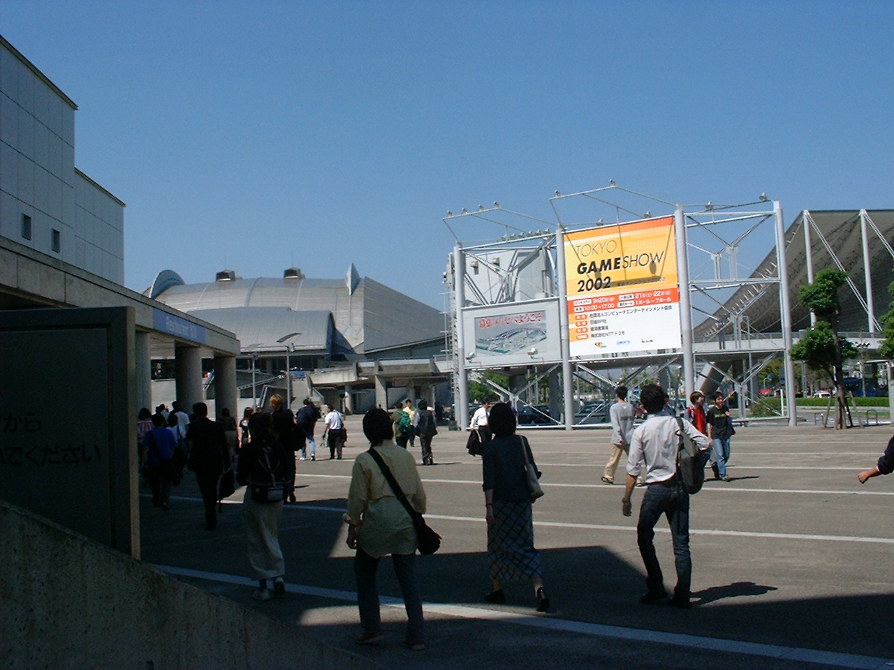 a sparse crowd walks toward a large building
