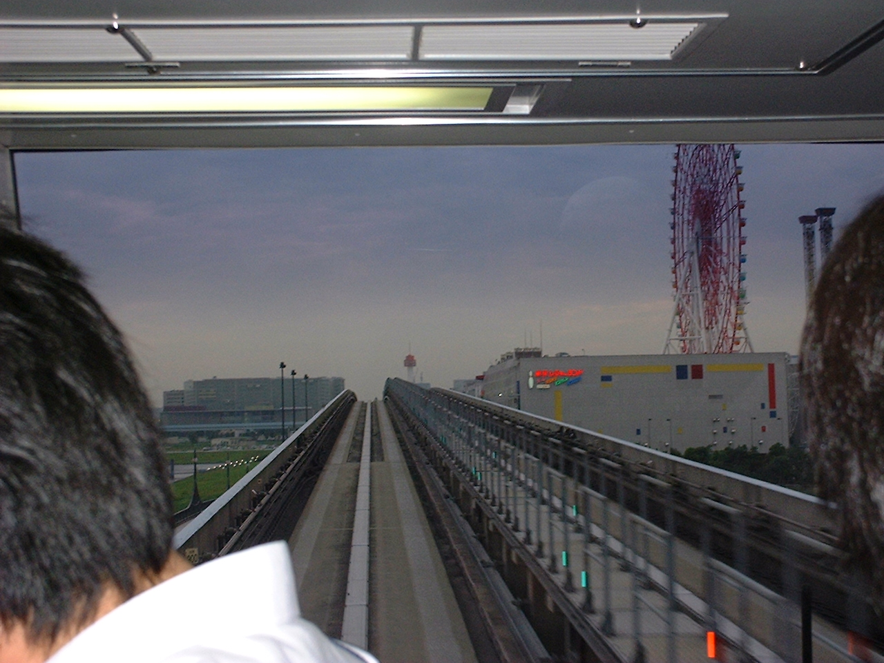 monorail view going up a hill near a ferris wheel
