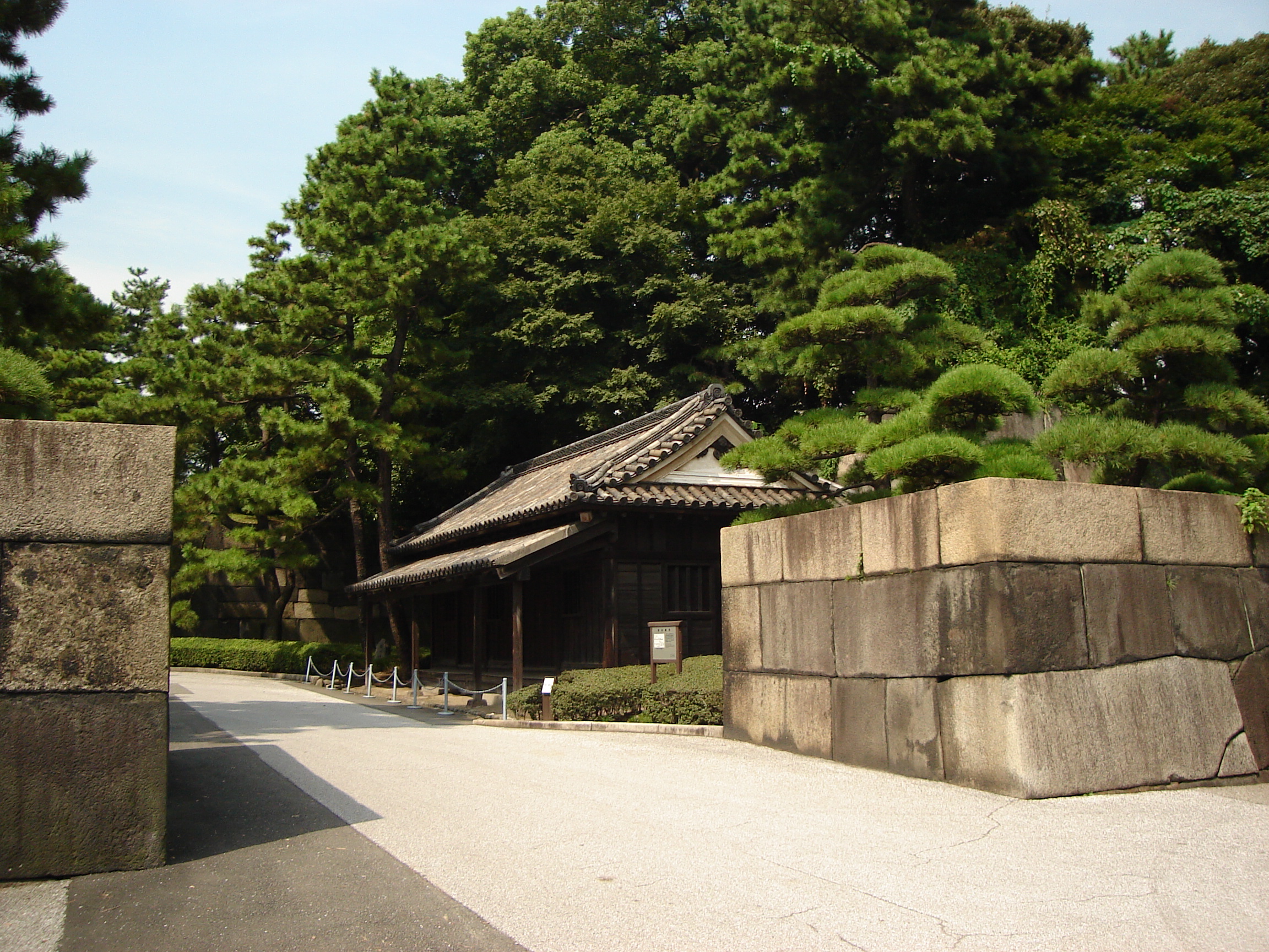a small building near the entrance dwarfed by trees