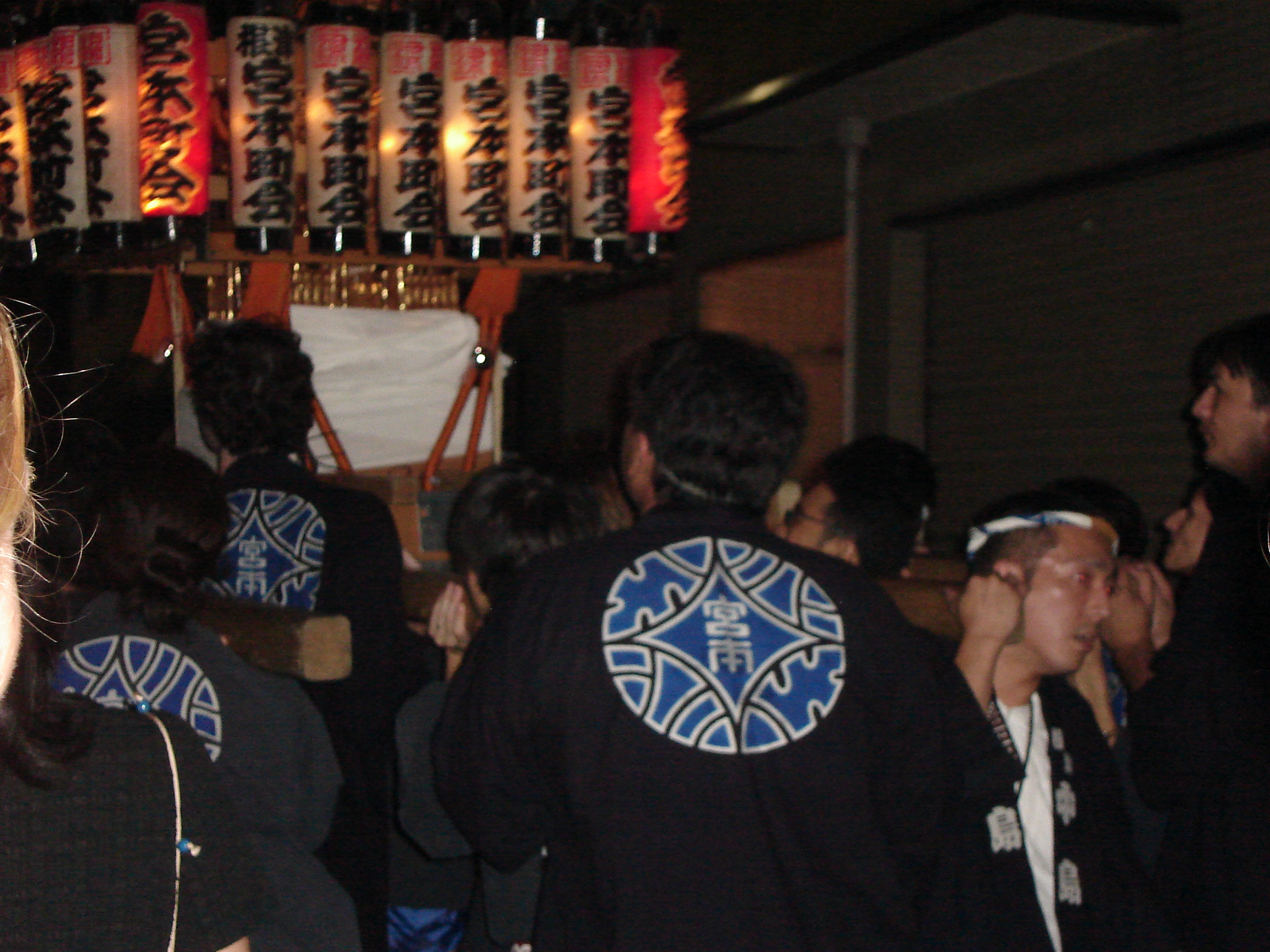 men carry the lit shrine at night