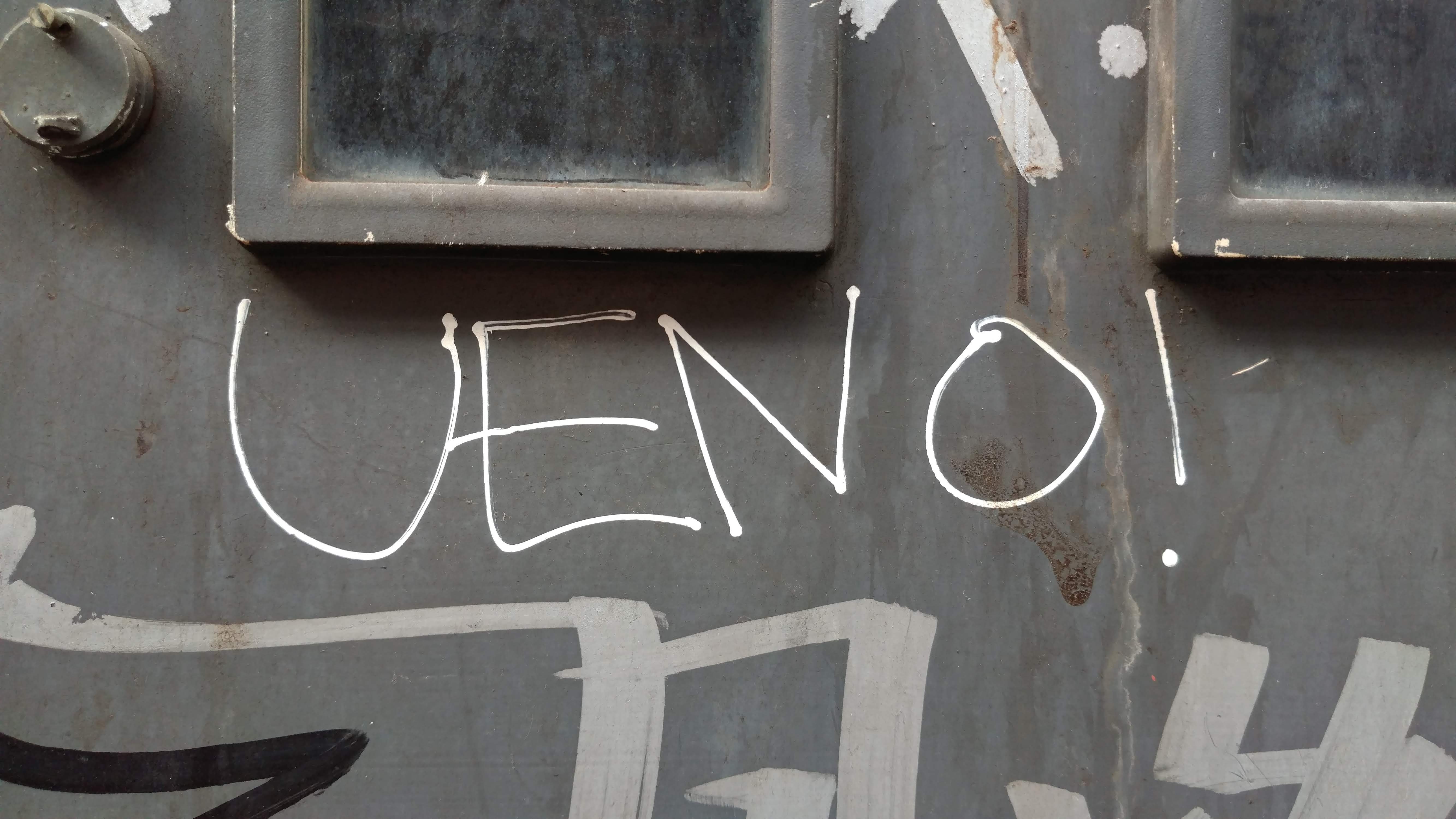 a grey wall with ueno! written on it in white grafitti