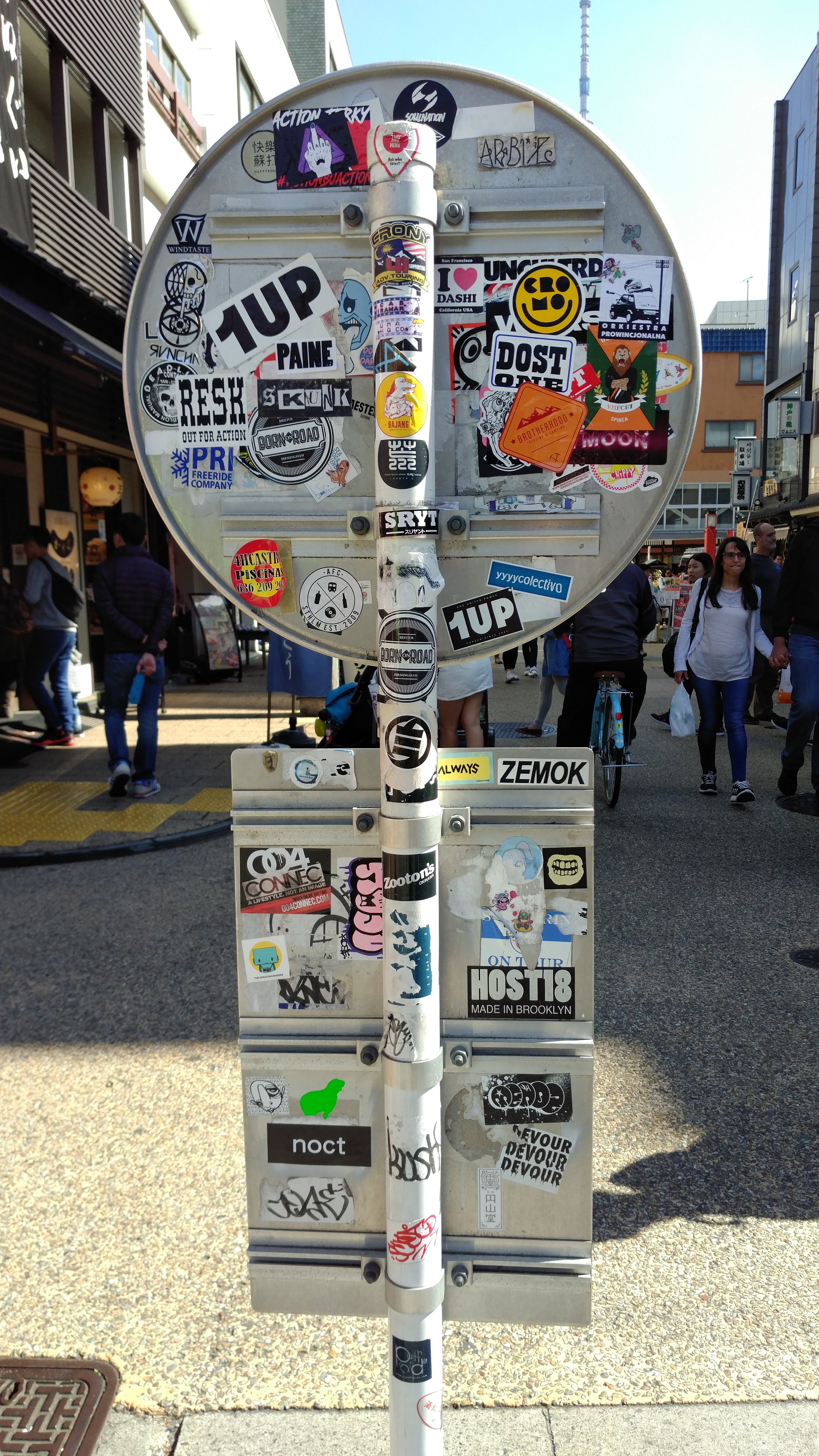 the back of a pair of signposts covered with stickers