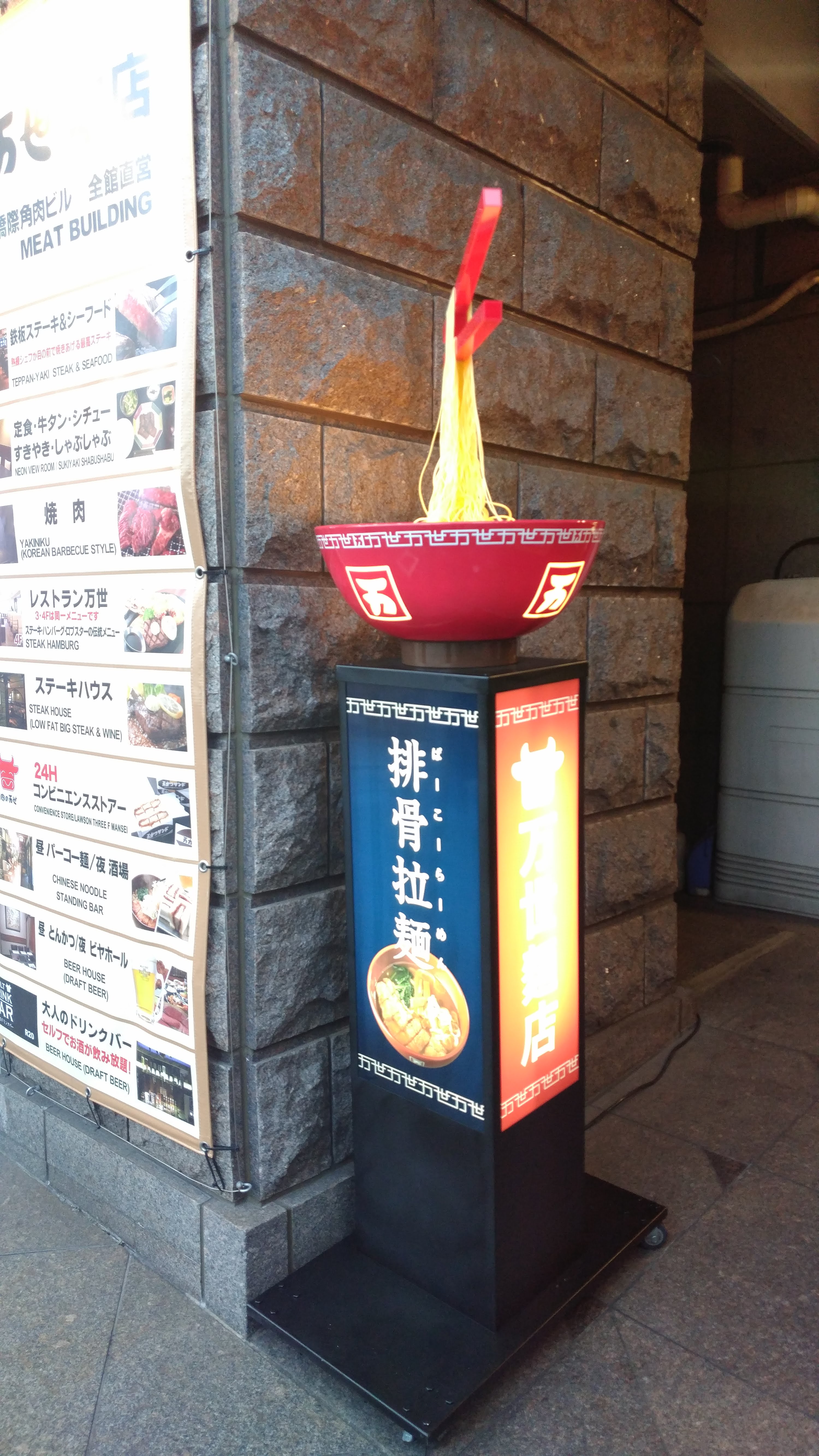 a sign outside a ramen shop with a model of ramen