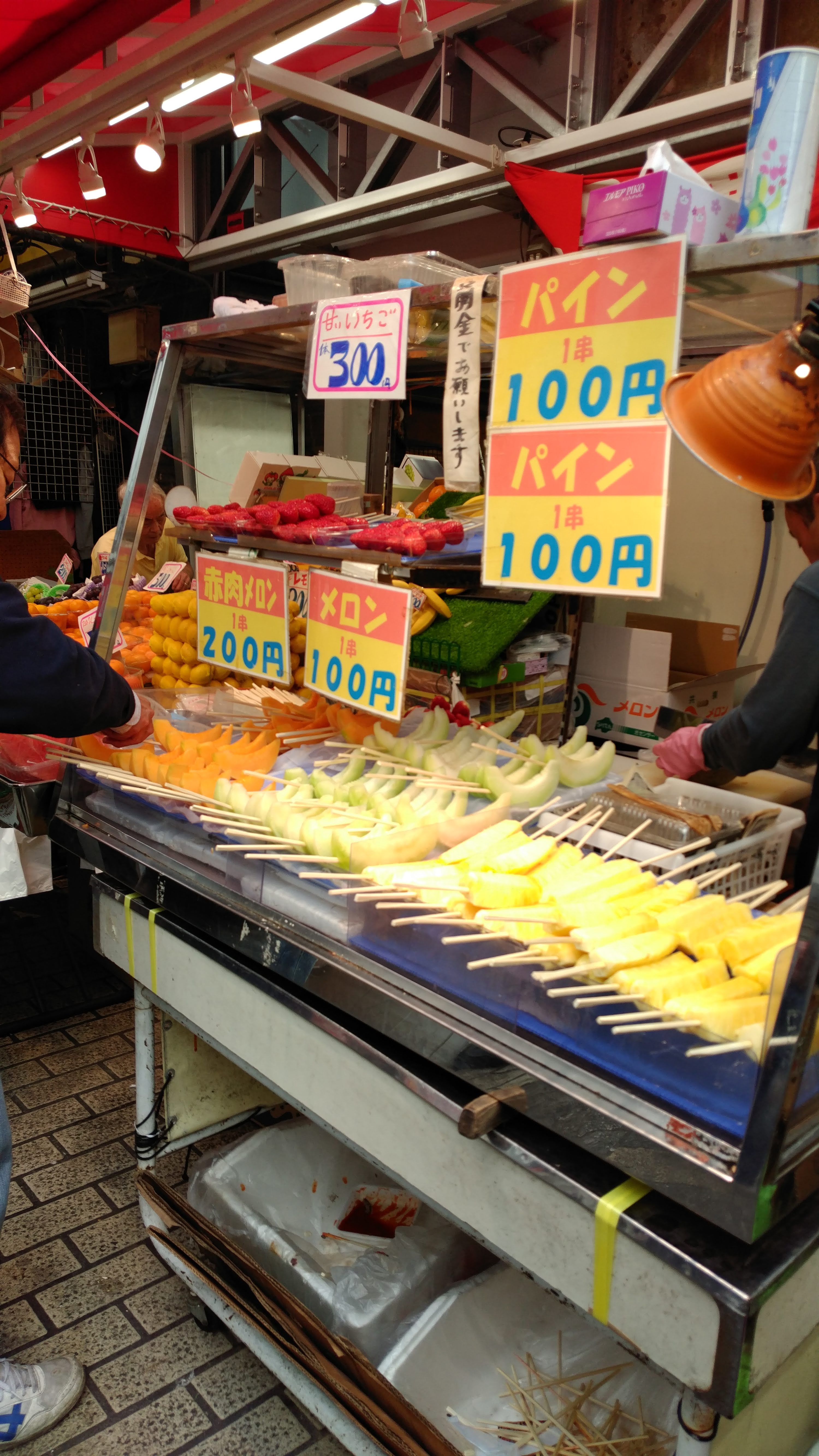 a stall selling fruit on a stick