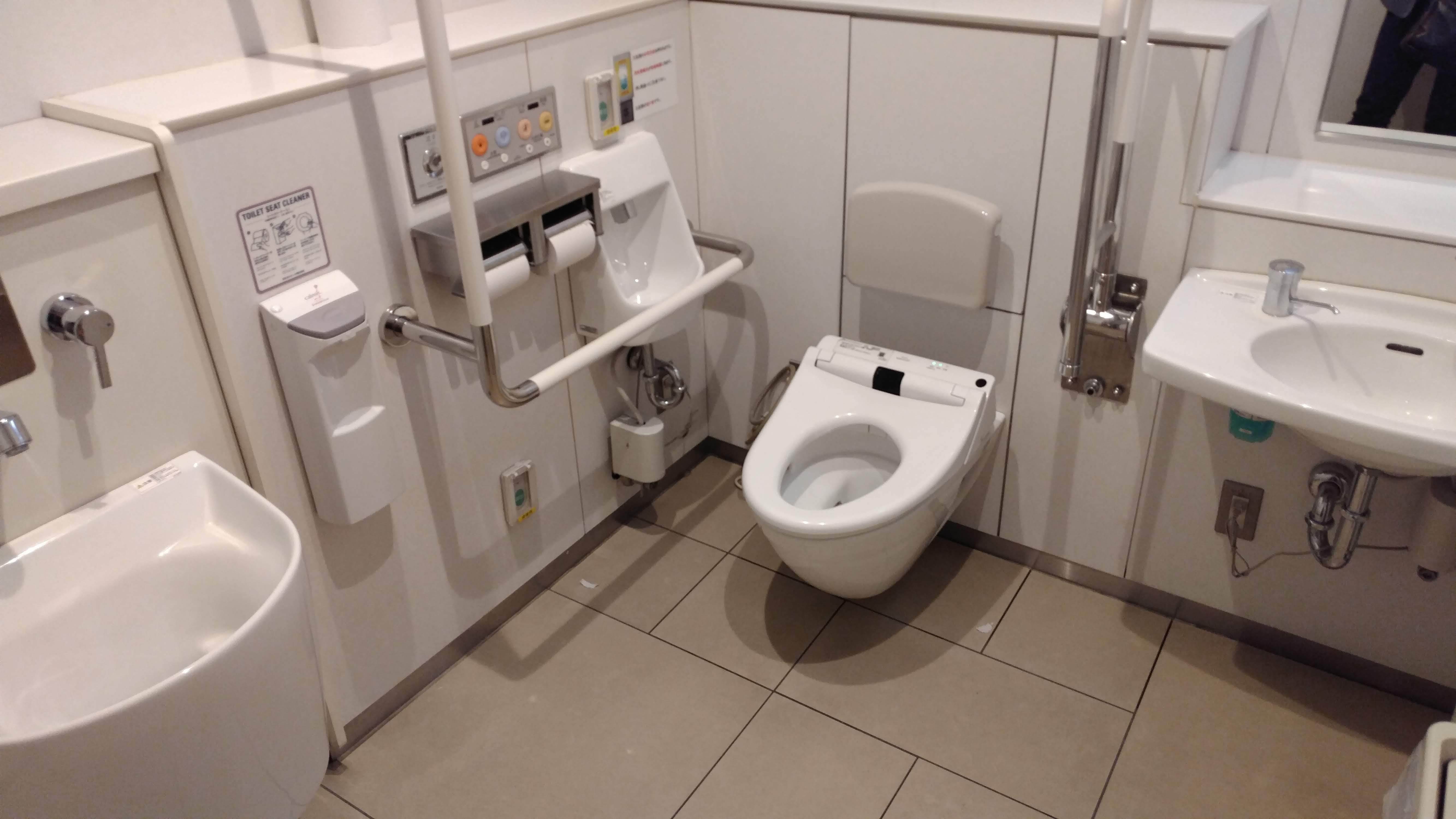roomy public bathroom with many accessibility features