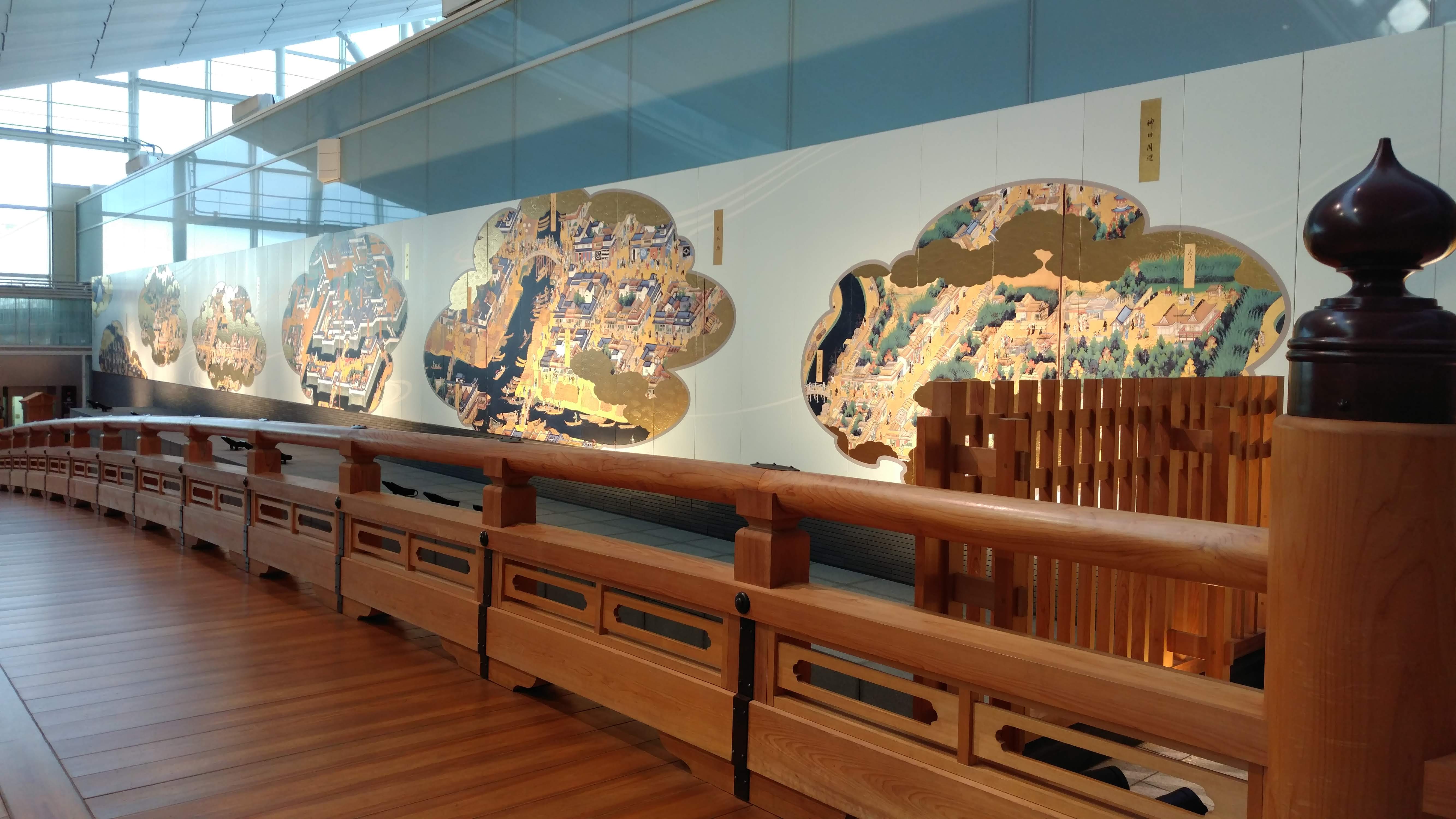 a wooden bridge with traditional artwork along one side