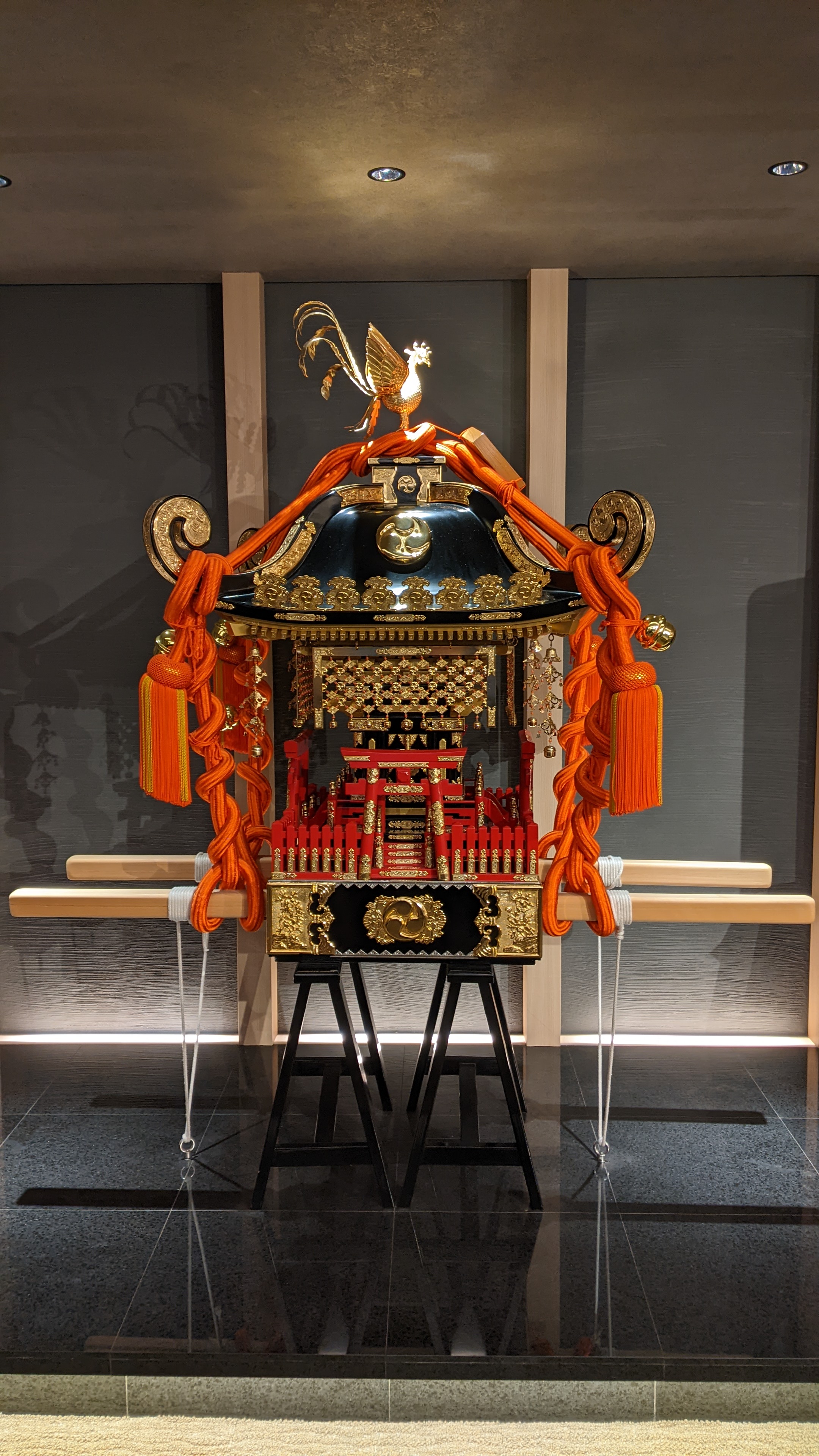 portable shrine with gold rooster on top and vermillion tassles