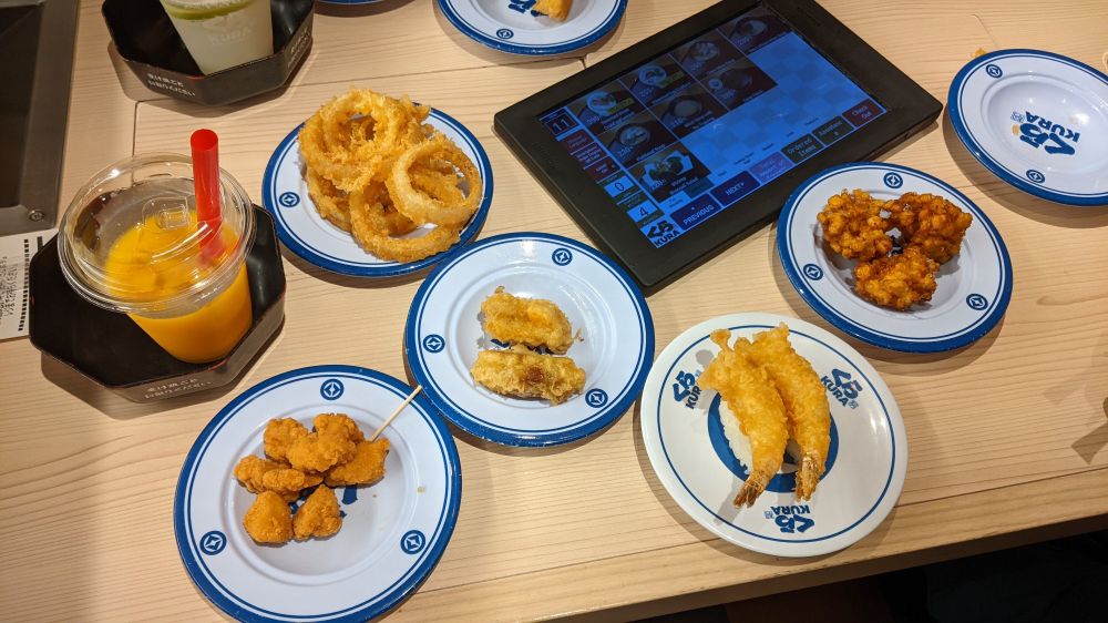 Small plates of fried foods and a mango drink