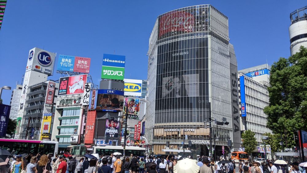 a crowd with several large buildings in the background