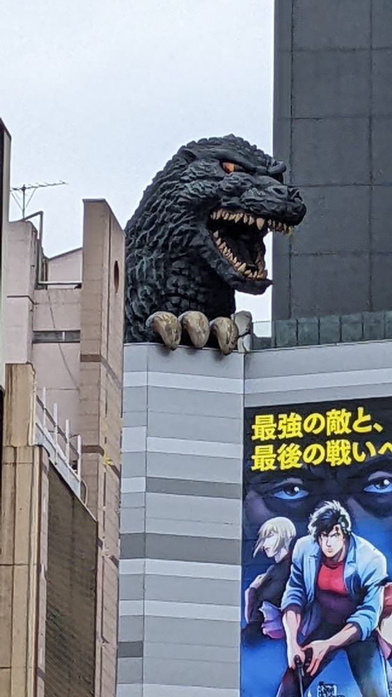 Godzilla's head looking out from the top of a building